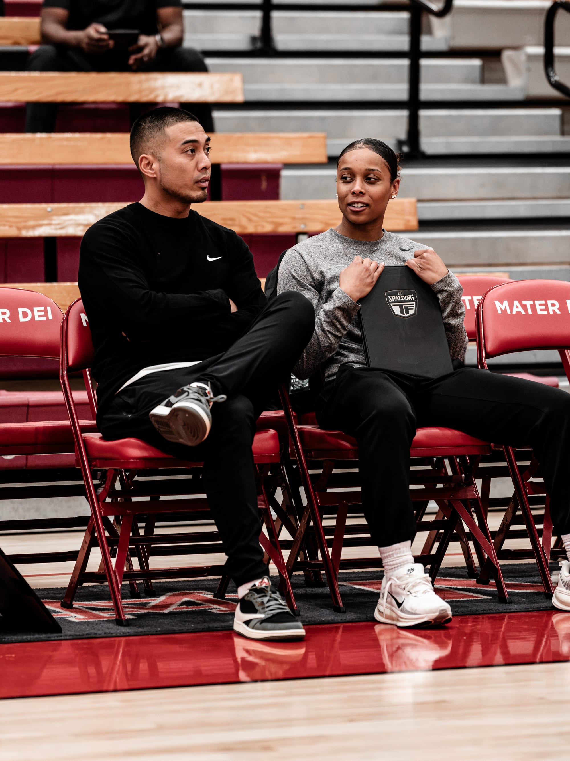 Coach Josh and Coach Asia courtside, walking through a play